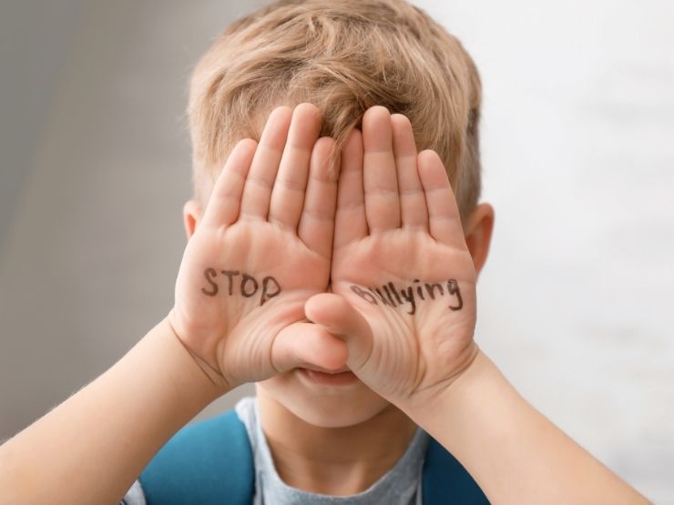 Un bambino con la scritta sulle mani: Stop al Bullismo