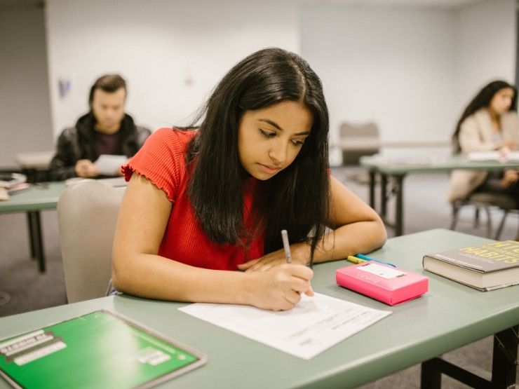 Studentessa sostiene un compito in classe