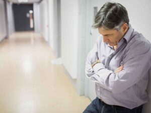 Un docente triste nel corridoio di una scuola, non riesce a trovare una casa dignitosa