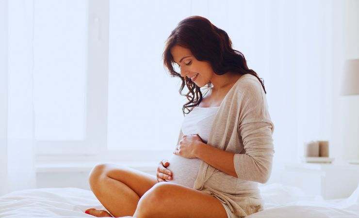donna incinta seduta e sorridente