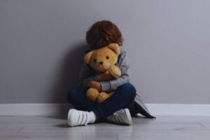 bambino abbraccia peluche