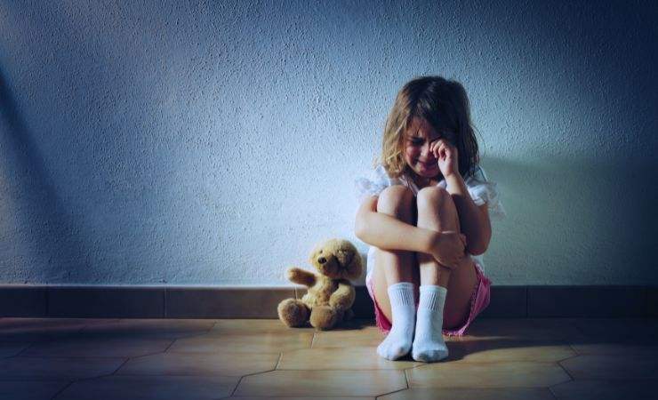 bambina piange seduta per terra