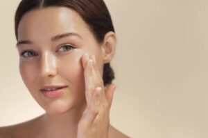 Donna stende la crema sul viso
