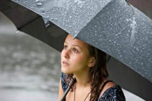 Donna sotto la pioggia con ombrello