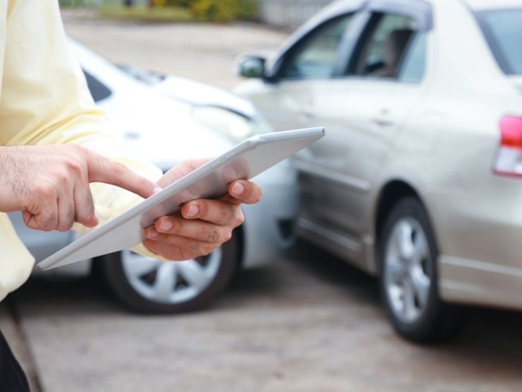incidente tra due auto, persona che consulta tablet