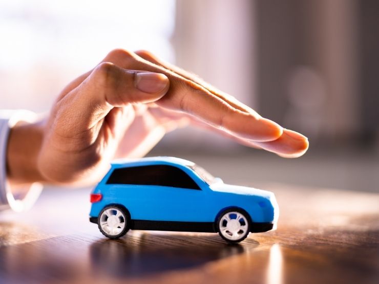 auto i miniatura e mano che la protegge