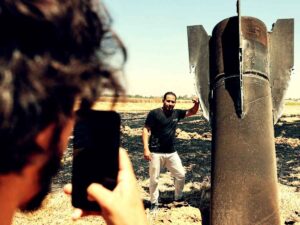 Un uomo si scatta una foto accanto ad un missile balistico iraniano