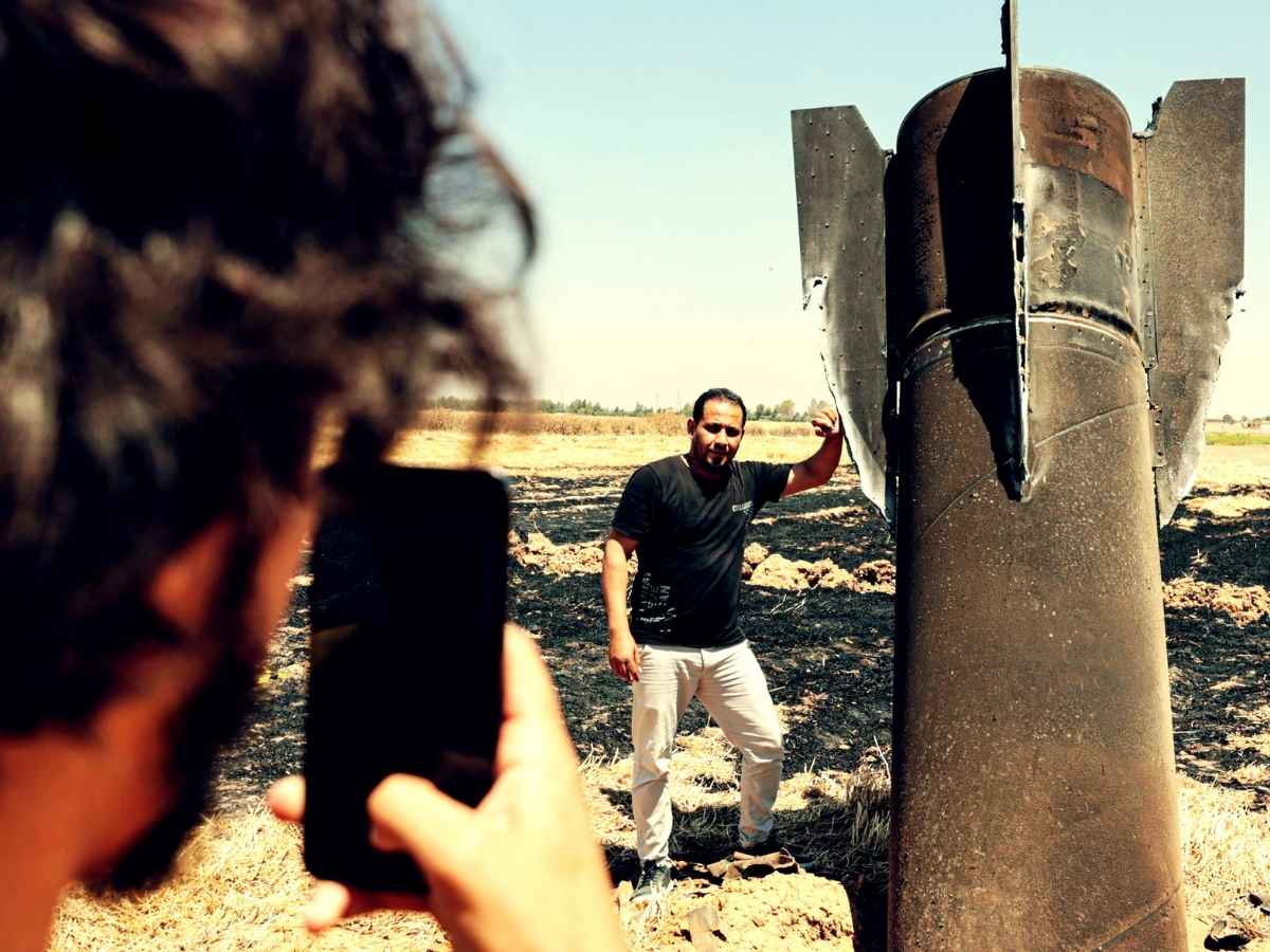 Un uomo si scatta una foto accanto ad un missile balistico iraniano