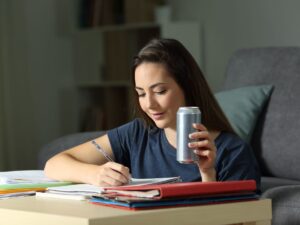 Ragazza beve energy drik mentre studia